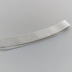 Metallic object with engraved text on a gray background