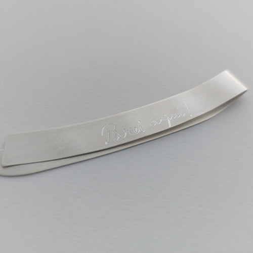 Metallic object with engraved text on a gray background