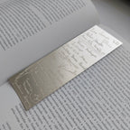 Metallic bookmark on an open book with text