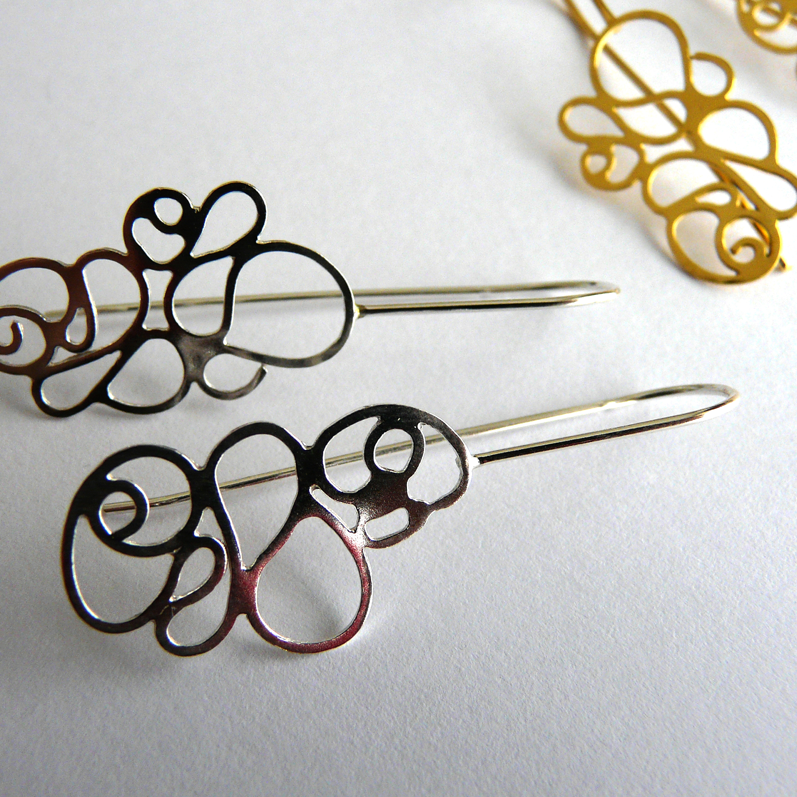 Decorative hair pins with intricate designs on a white background