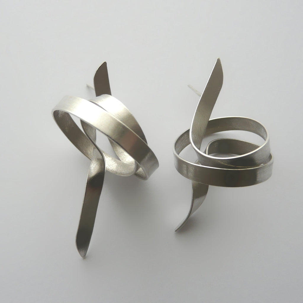 Pair of silver spiral earrings on a light gray background