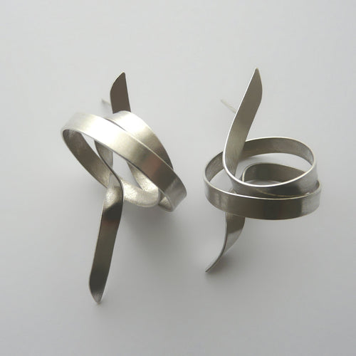 Pair of silver spiral earrings on a light gray background