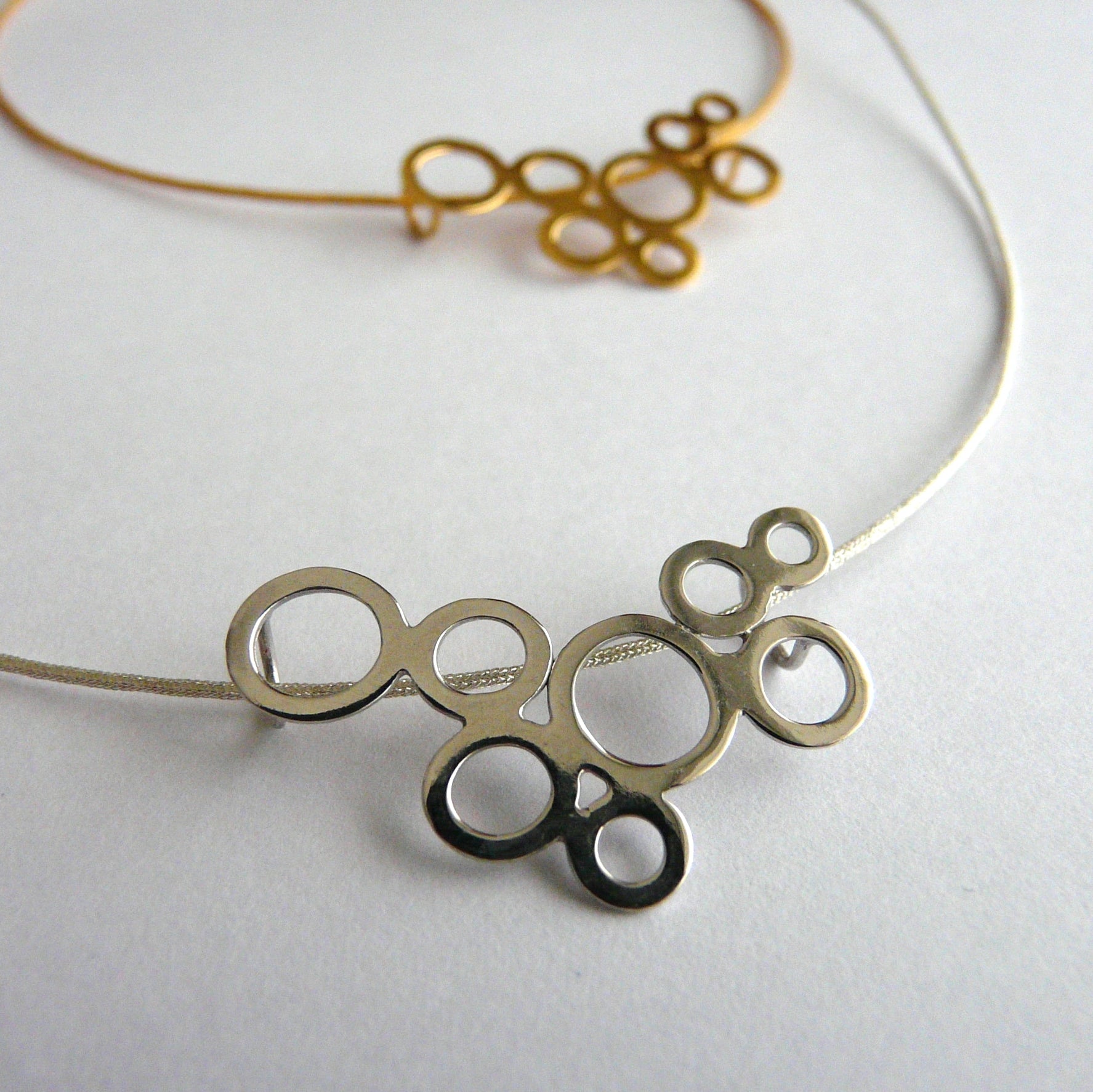 Gold and silver circular pendant necklace on a white background