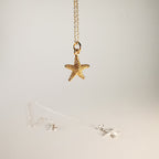Gold starfish pendant necklace on a light gray background