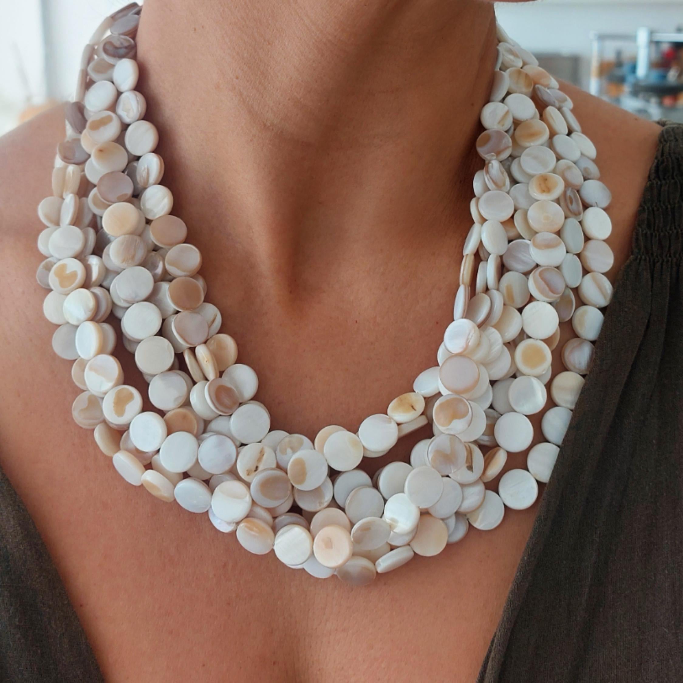 Necklace with round, beige beads worn by a person