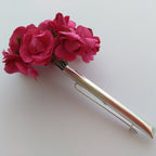 Silver hair clip with pink flowers on a white background