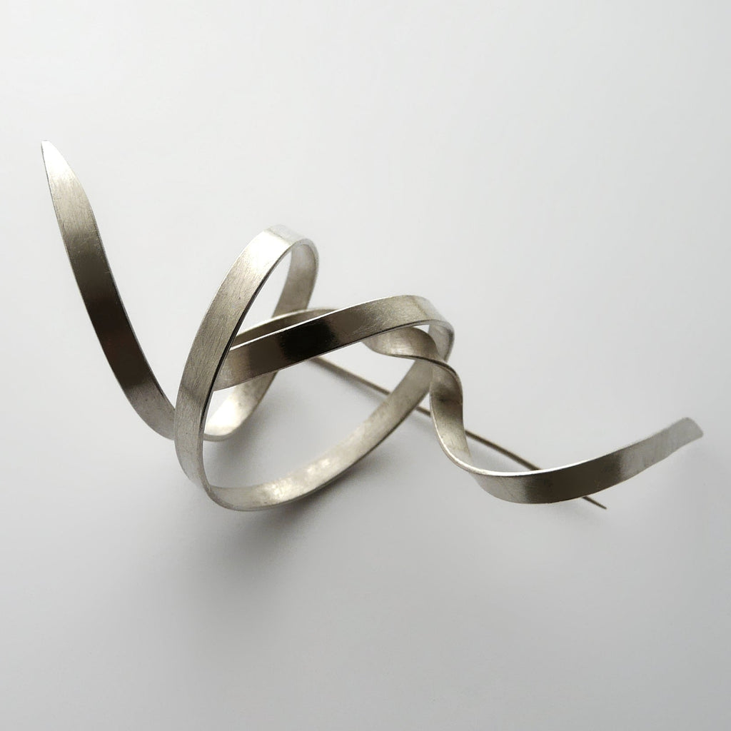 Silver abstract sculpture on a white background