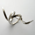 Silver abstract sculpture on a white background