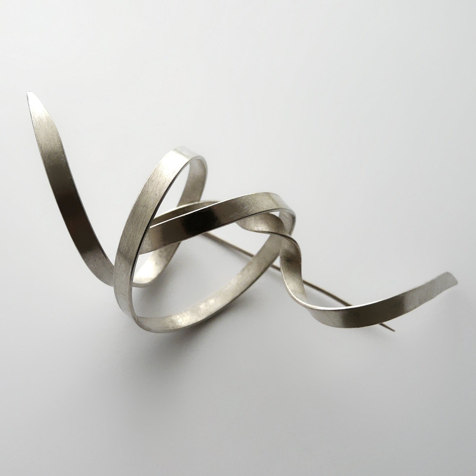 Silver abstract sculpture on a white background