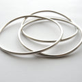 Three silver bangles on a white background