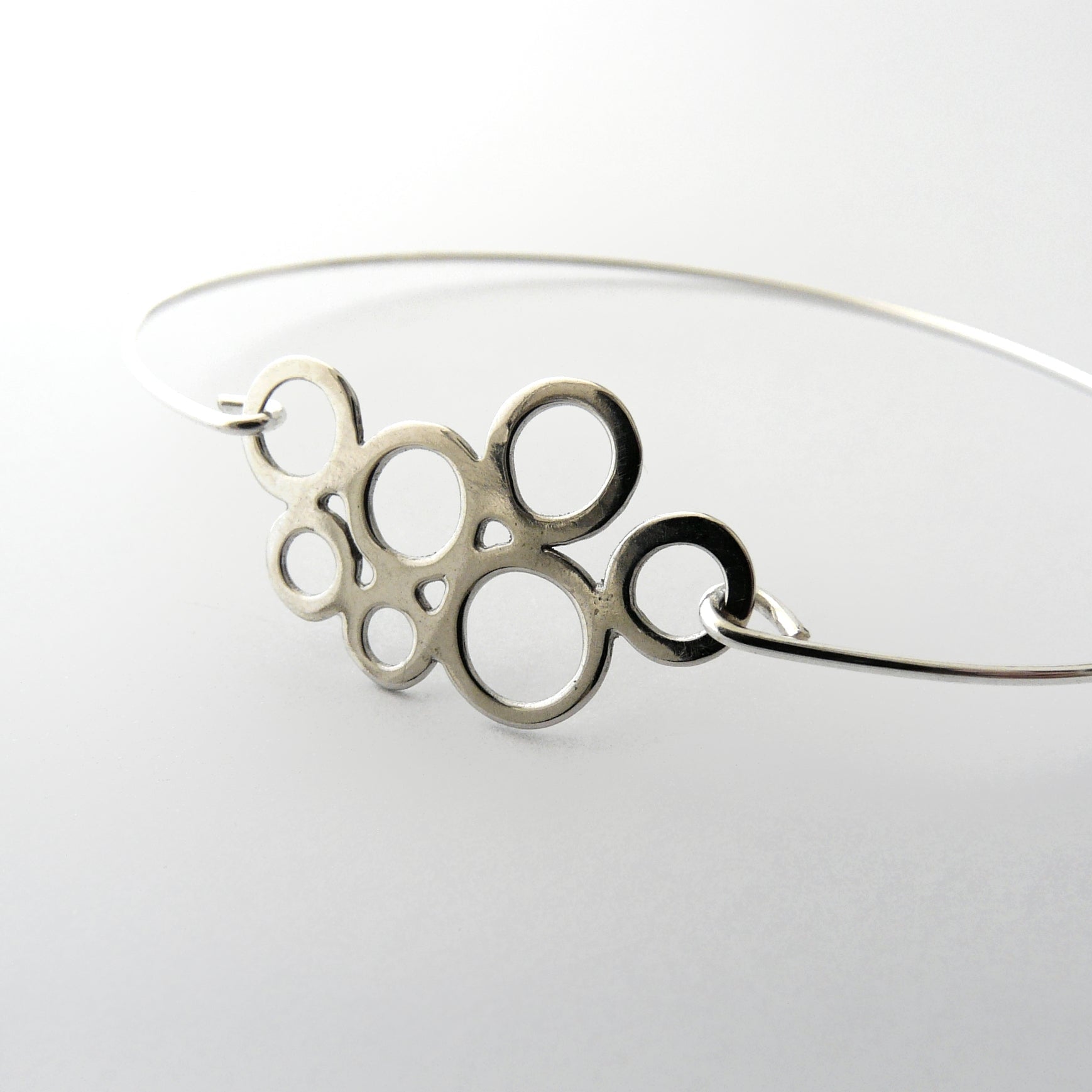 Silver circular bangle on a white background