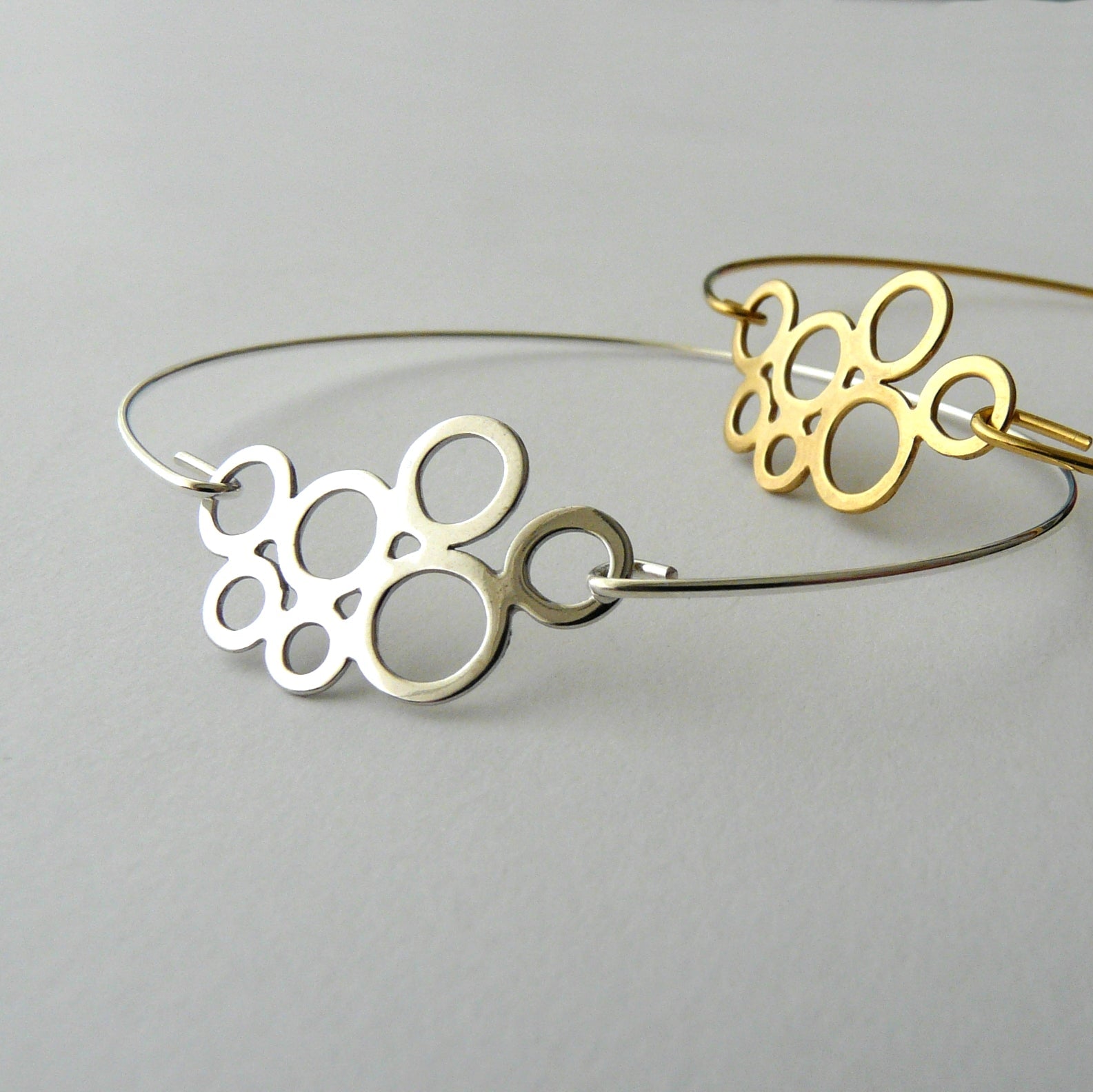 Gold and silver bangle bracelets on a light gray background
