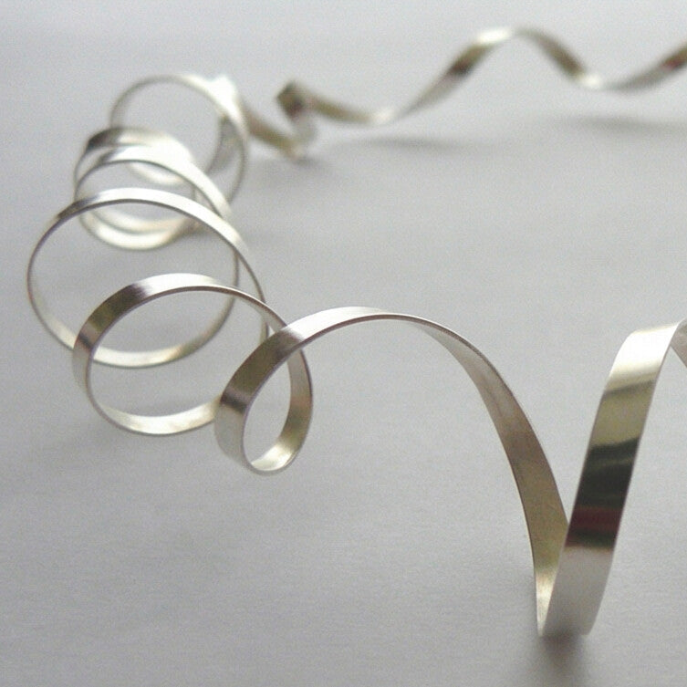 Silver spiral decorative item on a light gray background