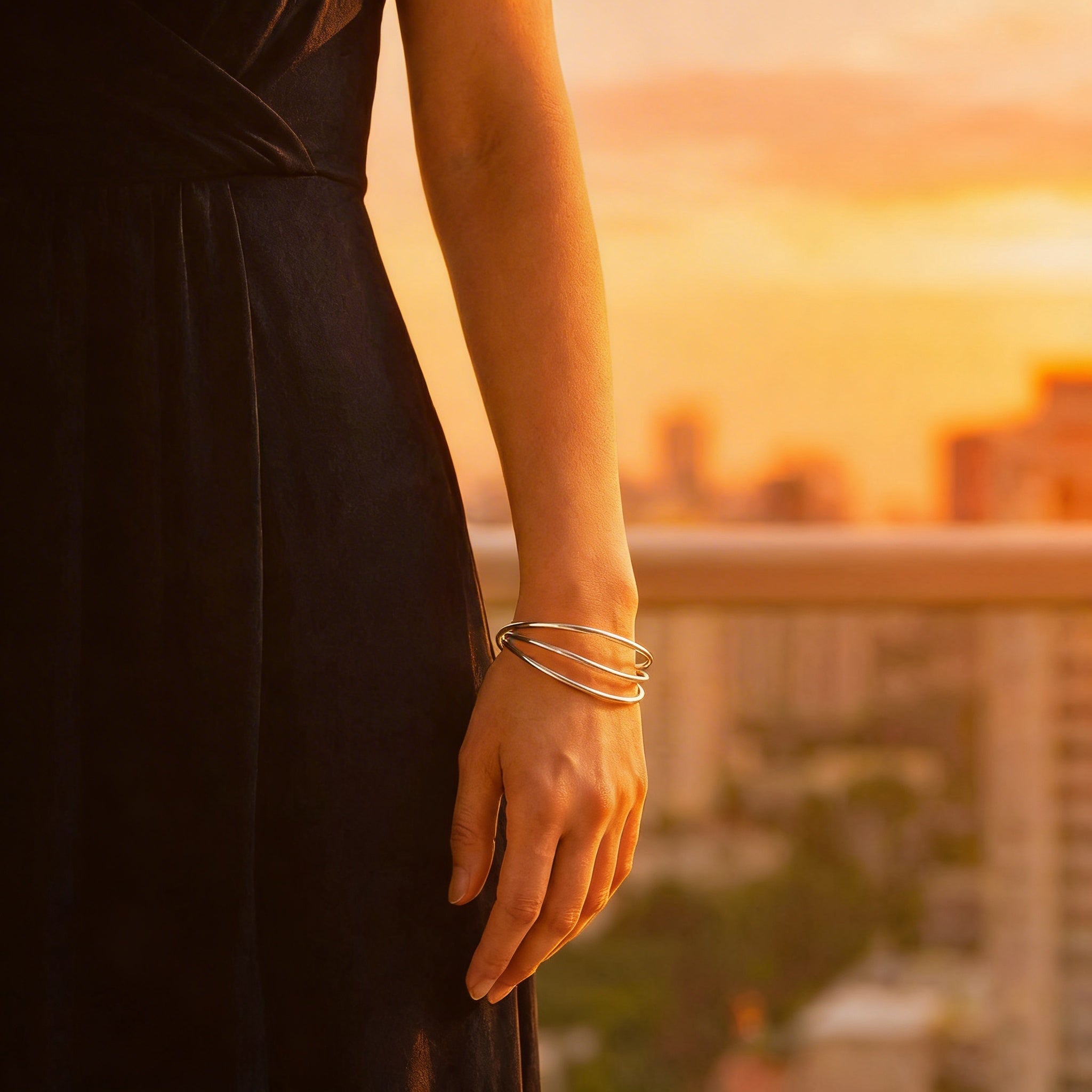 Person wearing a black dress with a sunset cityscape in the background